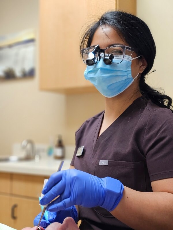 Registered Dental Hygienist In Dental Operatory With Patient