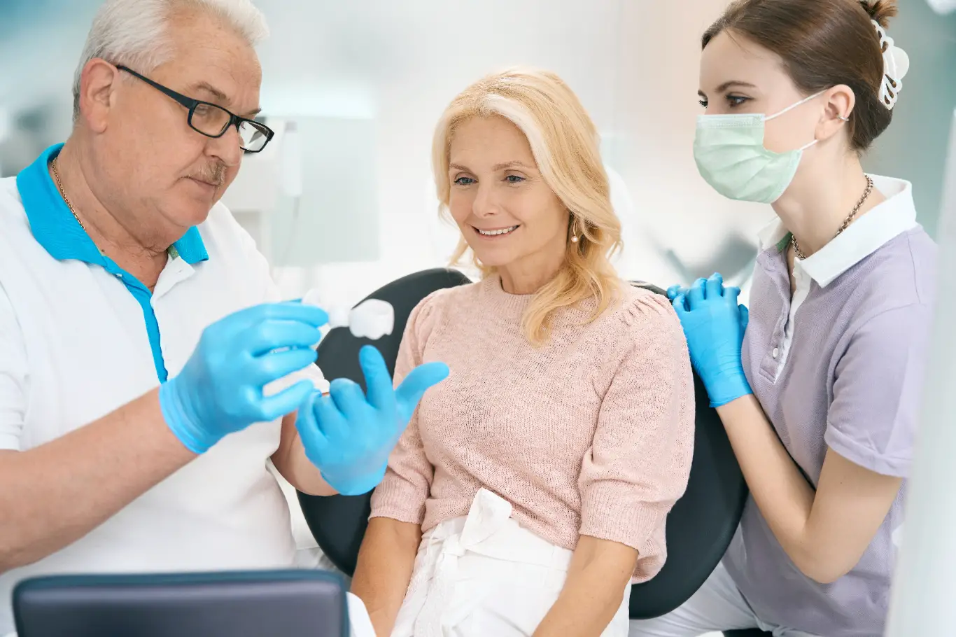 Woman discussing details of dental implants with her dentists